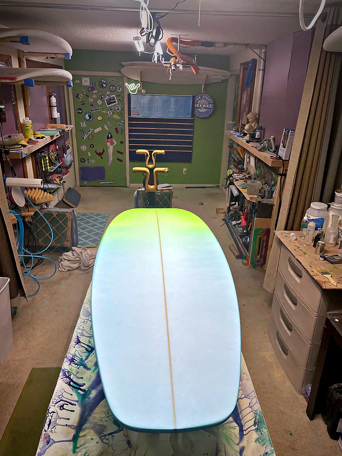 A lime-to-blue fade board on the stands, looking down the length of the Stanz Da Manz shop